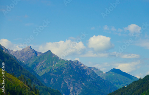 Panoramic view from Grubigstein, with rugged Zugspitze in background under blue sunny sky with cumulus clouds. Green valley at the foot of majestic alpine mountains, in Lermoos, Tyrol © familie-eisenlohr.de