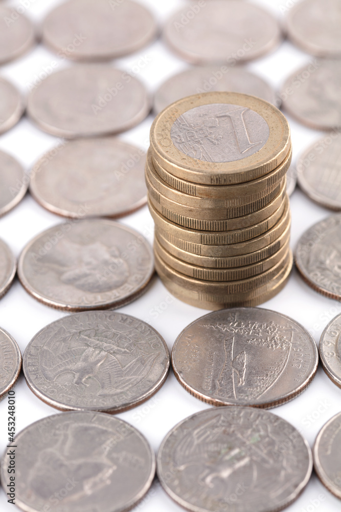 A stack of Euro coins in rolled out dollar coins A stack of Euro coins in rolled out dollar coins