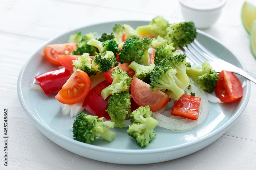 Plate of tasty salad with broccoli on light wooden background, closeup Plate of tasty salad with broccoli on light wooden background, closeup
