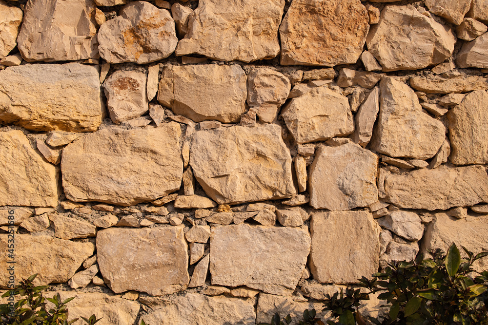 an artificial stone wall at sunny day for background an artificial stone wall at sunny day for background