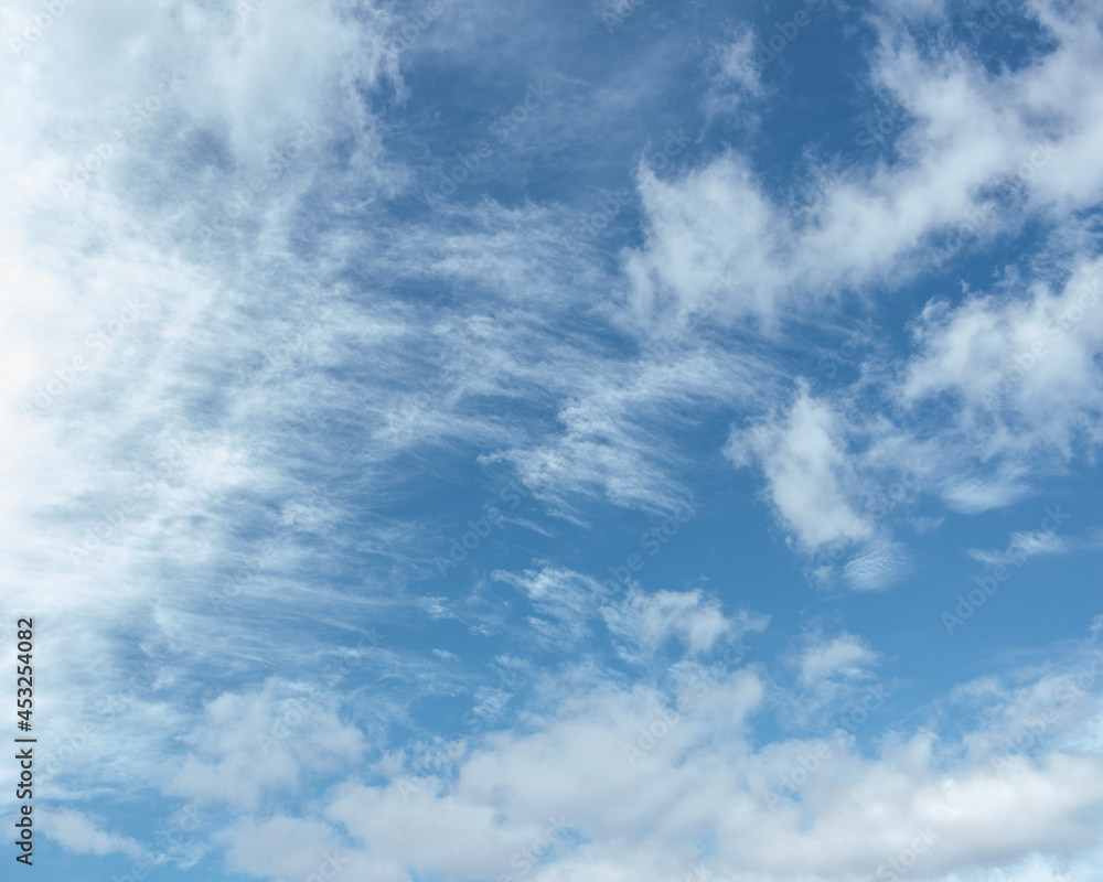 Cirrus clouds in the blue sky,beautiful Cirrus uncinus in the blue summer sky. Background of blue sky and white feathery clouds in summer. Cirrus clouds in the blue sky,beautiful Cirrus uncinus in the blue summer sky. Background of blue sky and white feathery clouds in summer.