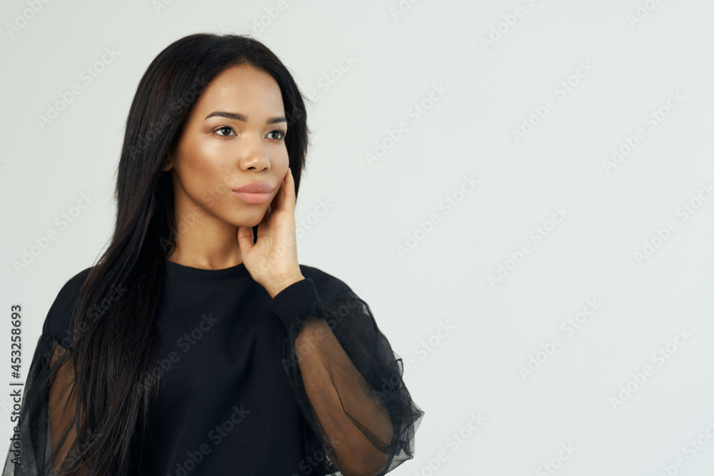 beautiful fashionable woman of african appearance dark shirt long hair light background beautiful fashionable woman of african appearance dark shirt long hair light background
