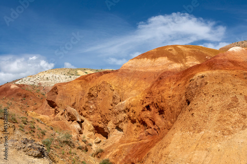 rocks made of colored clay against the backdrop of a beautiful blue sky