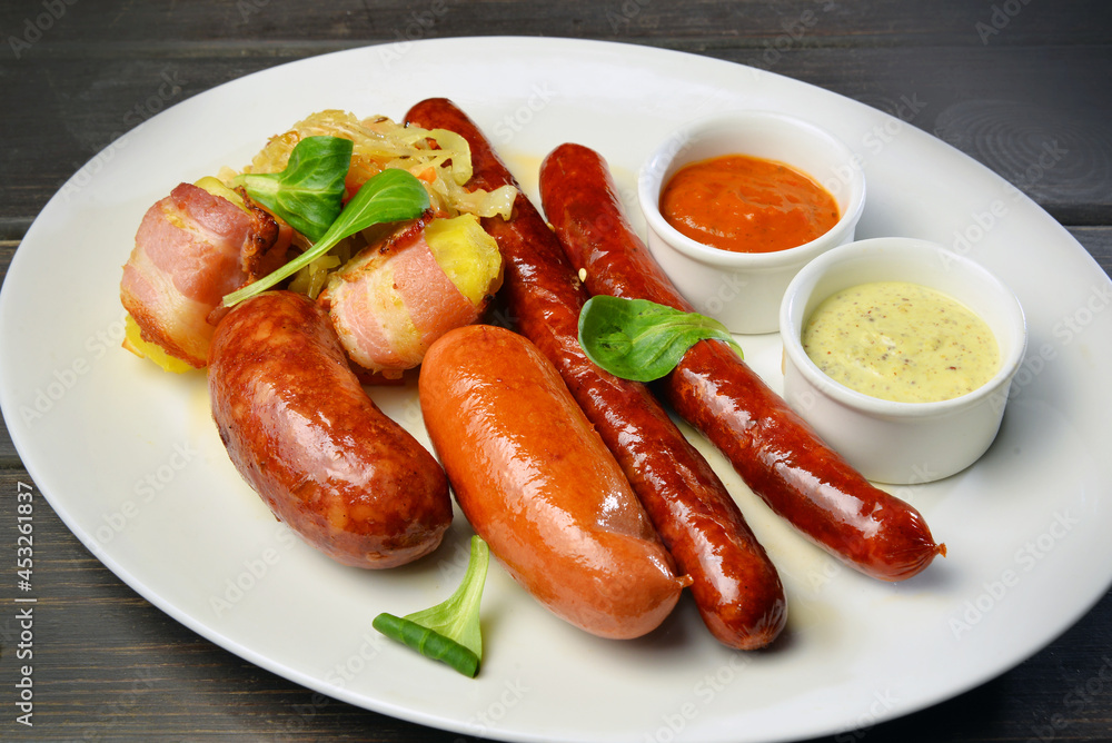 Grilled sausage with potato and sauce on a plate
