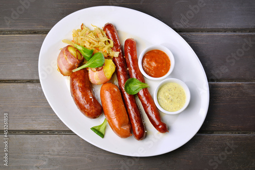 Grilled sausage with potato and sauce top view