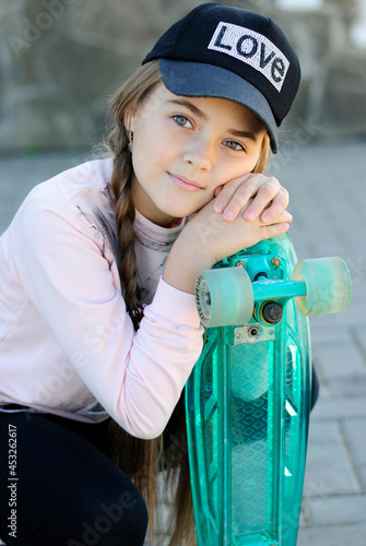 beautiful teenage girl with long hair in blue glasses and a plaid shirt on a skateboard