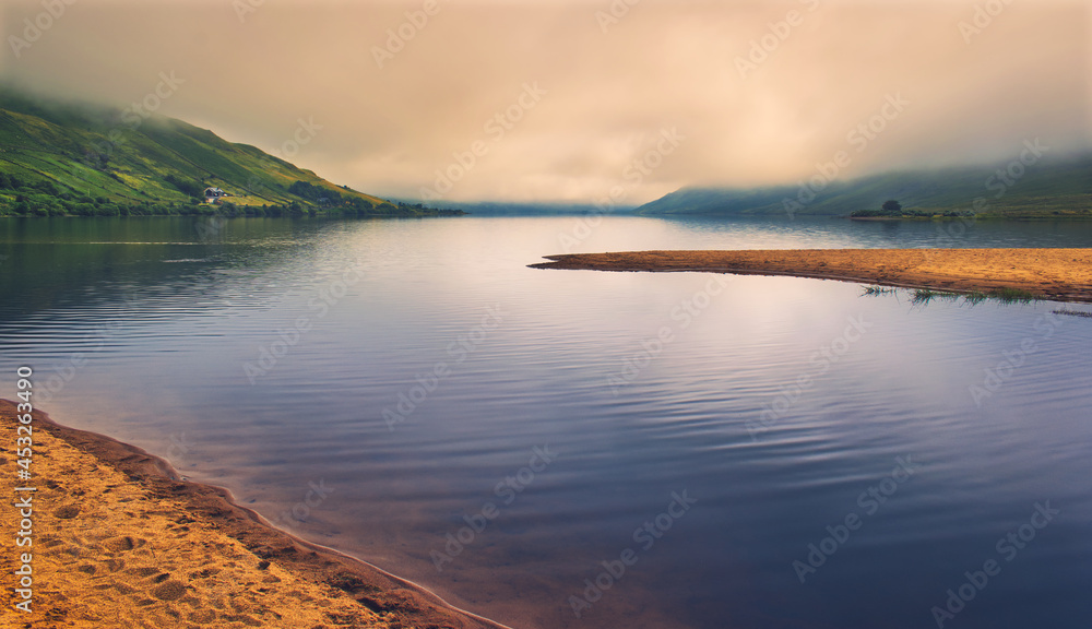 Beautiful morning foggy landscape scenery of sandy beach and crystal clear water at Loch Na Fooey in county Mayo, Ireland