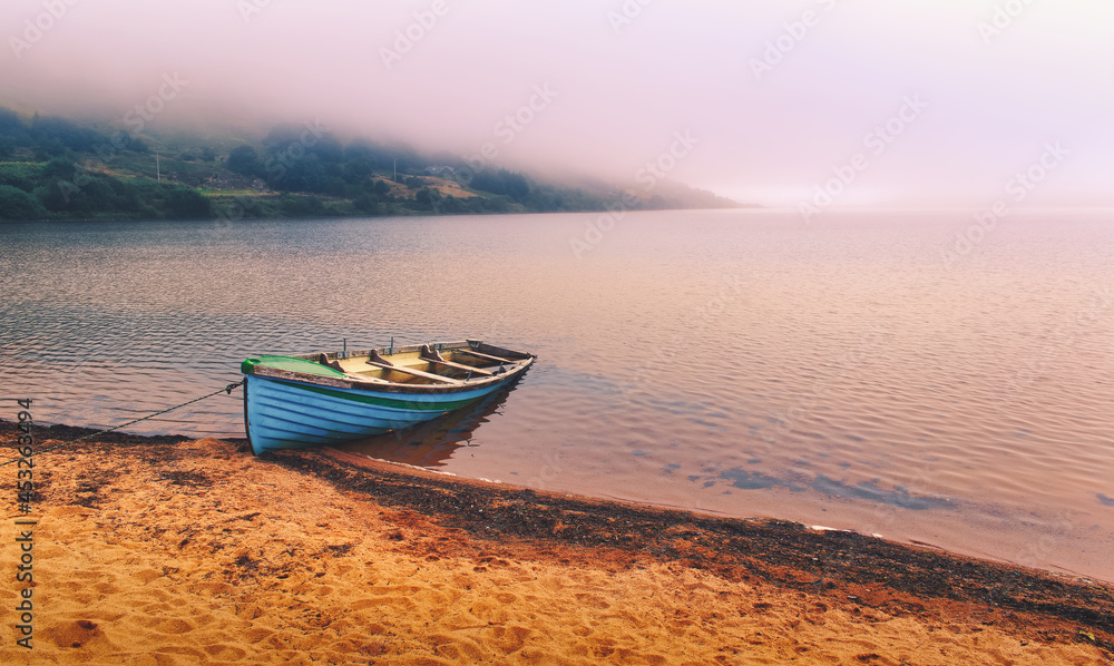 Beautiful landscape scenery of old wooden boat on the sandy beach of Loch Na Fooey in county Mayo, Ireland Beautiful landscape scenery of old wooden boat on the sandy beach of Loch Na Fooey in county Mayo, Ireland