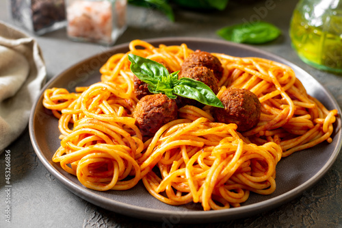 Spaghetti with meatballs in tomato sauce in a ceramic plate close-up. Traditional Italian pasta