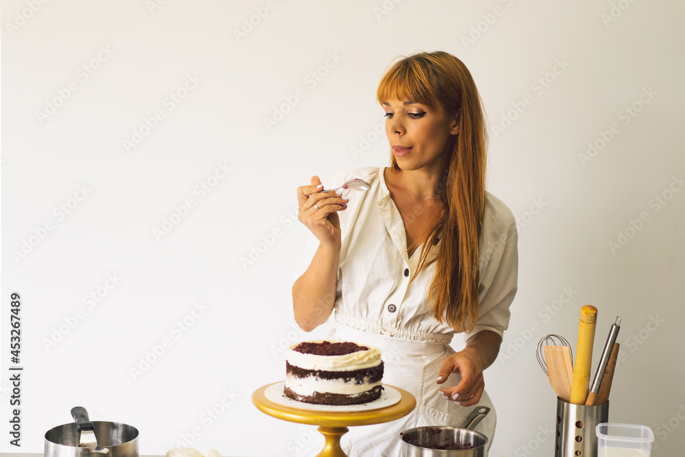 Confectioner girl is preparing a cake biscuit with white cream and chocolate. Cooking cakes. Confectioner girl is preparing a cake biscuit with white cream and chocolate. Cooking cakes.