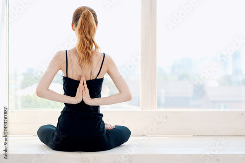 woman meditates near window calm exercise