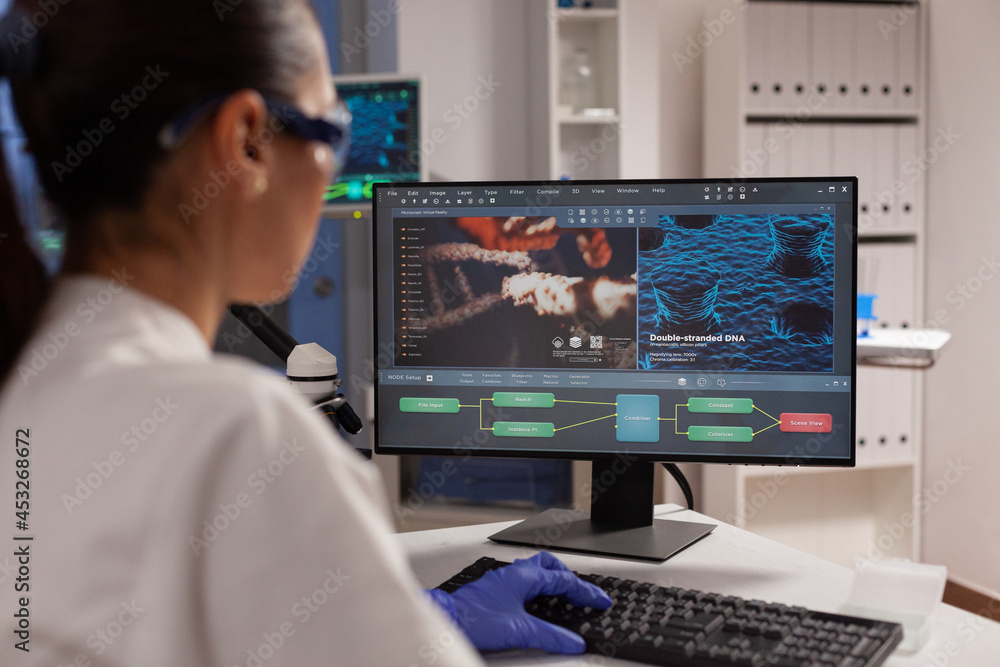 Science specialist using computer for dna research in microbiology laboratory. Professional woman working with illustration of plasma, cell tissue, bacteria invasion, hemoglobin diagram Science specialist using computer for dna research in microbiology laboratory. Professional woman working with illustration of plasma, cell tissue, bacteria invasion, hemoglobin diagram