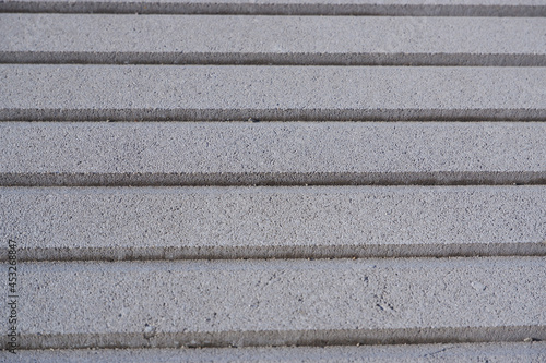 Pellet-stacked gray concrete curb. The texture of vibropressed concrete products. Building materials. Concrete road curbs