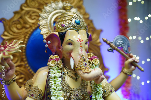 Ganesha Festival, Lord Ganesha statue on colourful background with jewellery photo