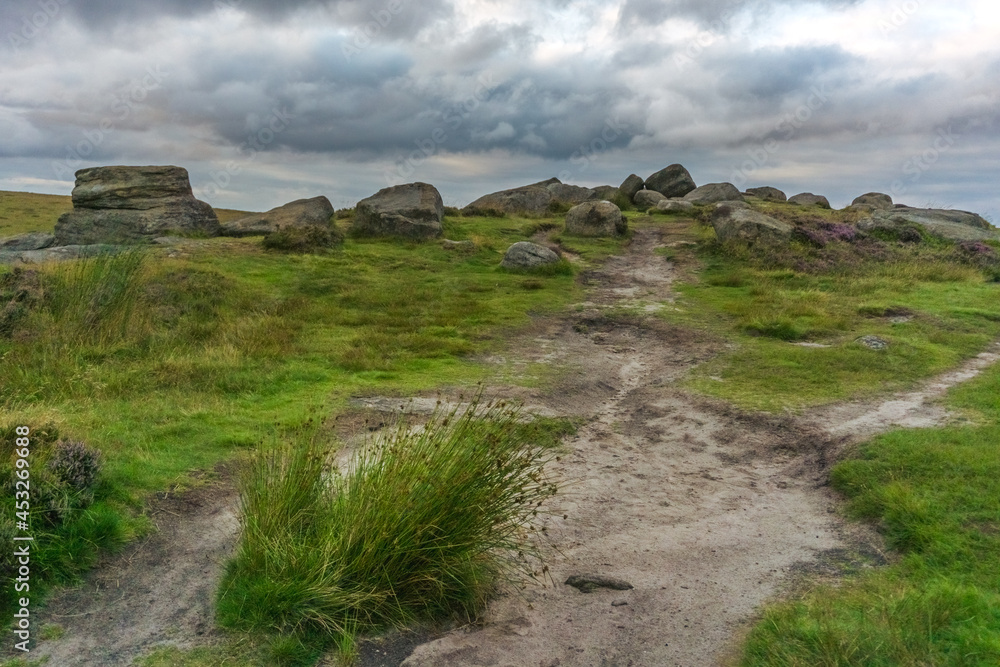 A Beautiful View of Stanage Edge With Rocks and a Tail Path with Heavy, Dramatic Clouds in Peak District, Sheffield, England