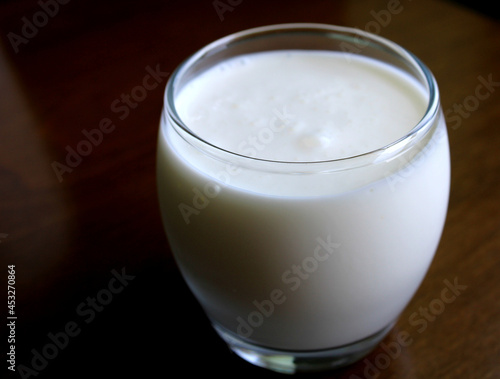 Glass of kefir drink on wooden table