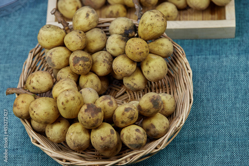 bunch of ripe Longkong fruit in wicker basket photo