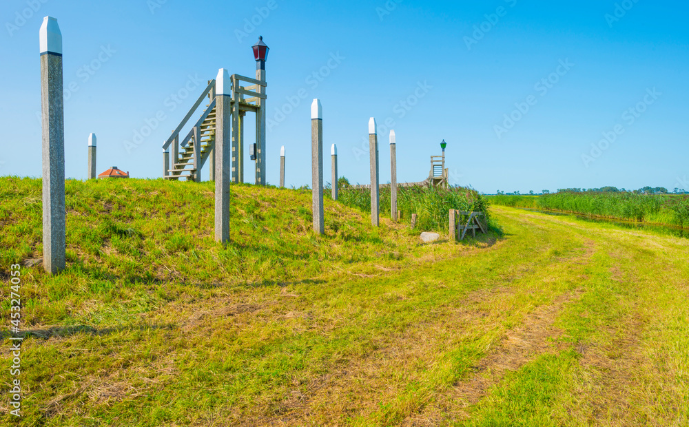 Fototapeta premium Unesco protected outline of an ancient former harbor of an island swallowed by reclaimed new land under a blue sky in summer, Noordoostpolder, Schokland, Flevoland, Netherlands, August 23, 2021