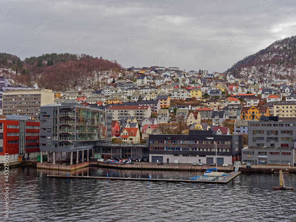 Apartments, Houses and Maritime Buildings all mixed up with one another on the waterfront of Bergen Port on a wintry day in April.