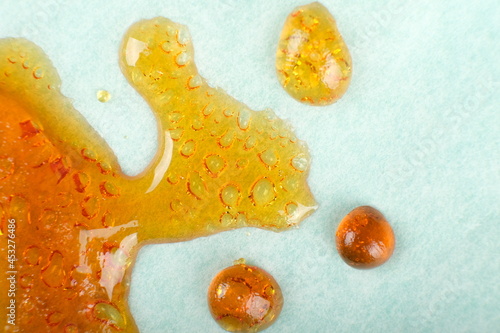 Fotografie cured orange-yellow cannabis wax, marijuana resin dab closeup.