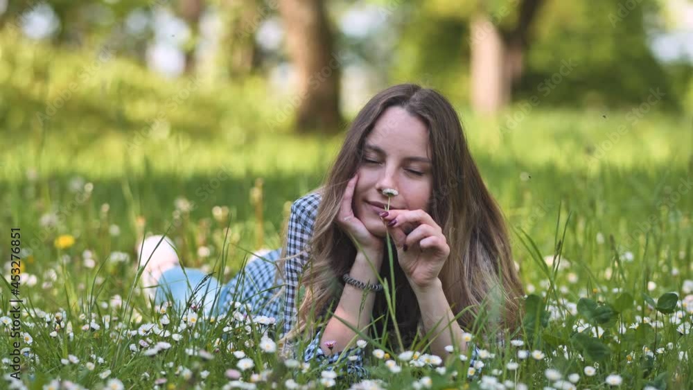 A beautiful young girl lies on the grass on a summer evening. A beautiful young girl lies on the grass on a summer evening.