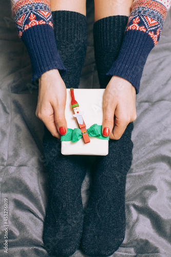 Girl Holding Holiday Gift On Her Feet