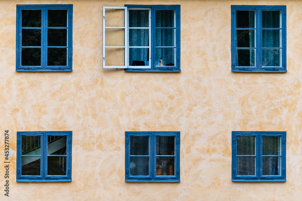Six wooden blue painted windows on plaster wall. Architectural background