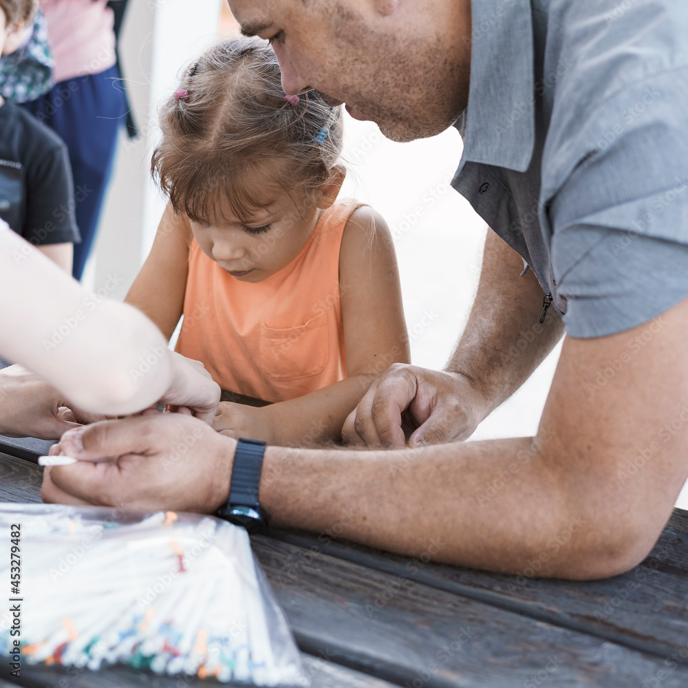 Obraz premium dad and daughter spend time together. cute caucasian girl takes part in a master class for making paper crafts