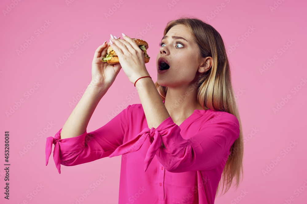 cheerful blonde in a pink shirt hamburger fast food snack cheerful blonde in a pink shirt hamburger fast food snack