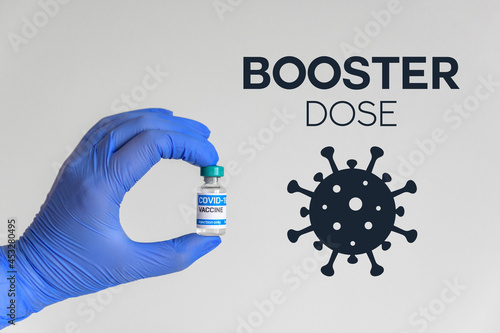 Medical worker holding vaccine in front of white background and booster dose text photo