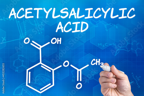 hand with pen drawing the chemical formula of acetylsalicylic ac photo