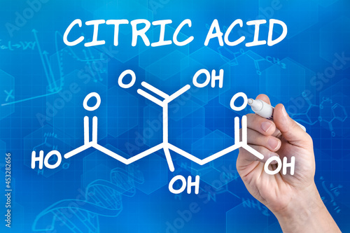 Fotografie hand with pen drawing the chemical formula of citric acid