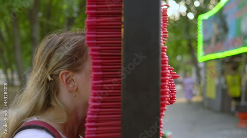 The girl in the park prints her face in a large inprint. Printing 3d figurines of a part of a person photo