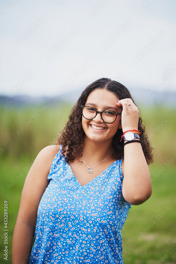 Young spanish girl smiling at camera on green field