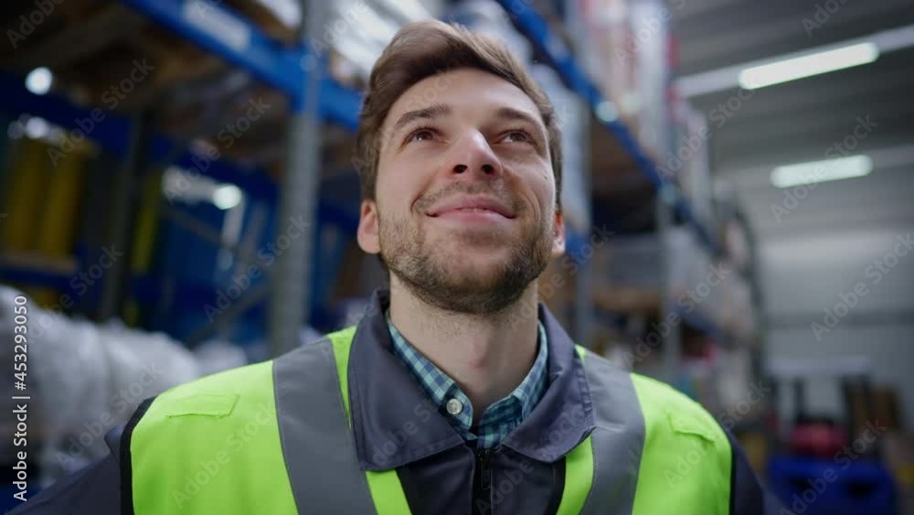Close-up portrait of handsome brunette unshaved man with brown eyes smiling looking at cargo racks in industrial storage. Headshot of satisfied Caucasian male worker in warehouse indoors Close-up portrait of handsome brunette unshaved man with brown eyes smiling looking at cargo racks in industrial storage. Headshot of satisfied Caucasian male worker in warehouse indoors