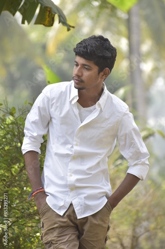 Handsome Men Posing In White T Shirt On Outdoor Nature Background. Men Holding Shirt on Hands. Indian Men  Men Model from Asia. Walking.