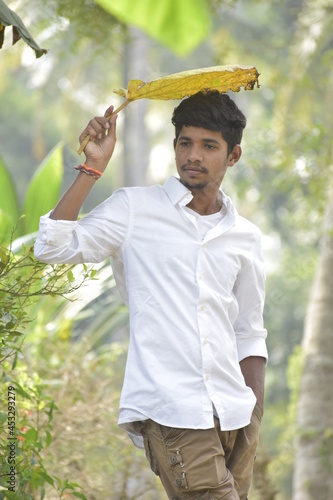 Handsome Men Posing In White T Shirt On Outdoor Nature Background. Men Holding Shirt on Hands. Indian Men  Men Model from Asia. Walking.