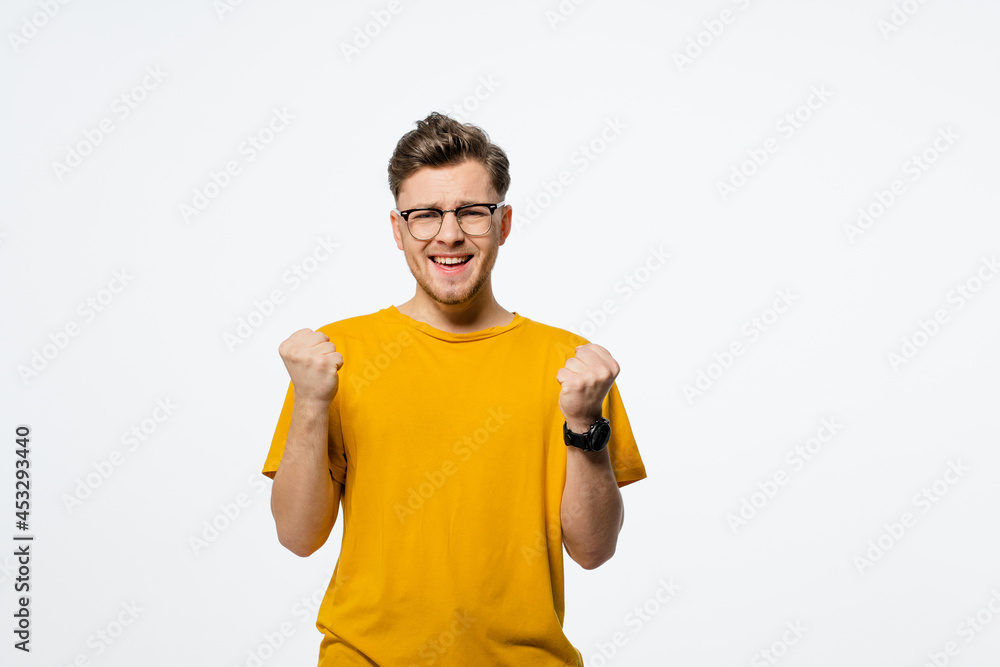 Casual man winning and celebrating handsome young man with hands lifted up. Young casual man portrait isolated on white background. Human emotions, facial expression concept. Casual man winning and celebrating handsome young man with hands lifted up. Young casual man portrait isolated on white background. Human emotions, facial expression concept.