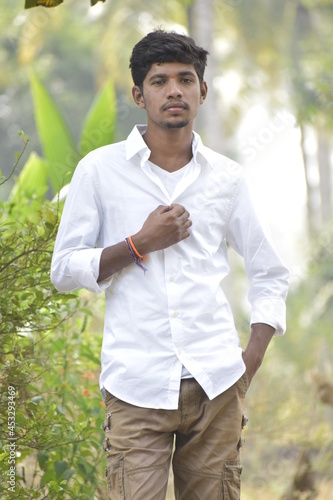 Handsome Men Posing In White T Shirt On Outdoor Nature Background. Men Holding Shirt on Hands. Indian Men  Men Model from Asia. Walking.