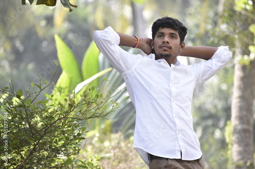 Handsome Men Posing In White T Shirt On Outdoor Nature Background. Men Holding Shirt on Hands. Indian Men  Men Model from Asia. Walking.