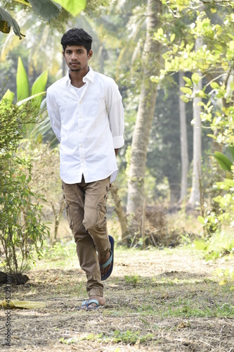 Handsome Men Posing In White T Shirt On Outdoor Nature Background. Men Holding Shirt on Hands. Indian Men  Men Model from Asia. Walking.