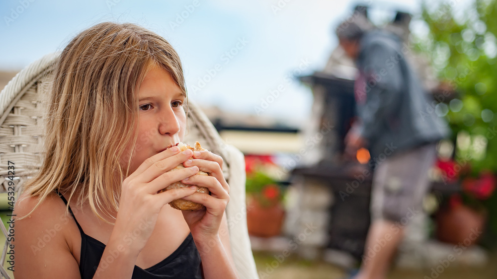 BBQ grilling party. Beautiful girl enjoying barbecue at outdoors. Food, people and family time concept
