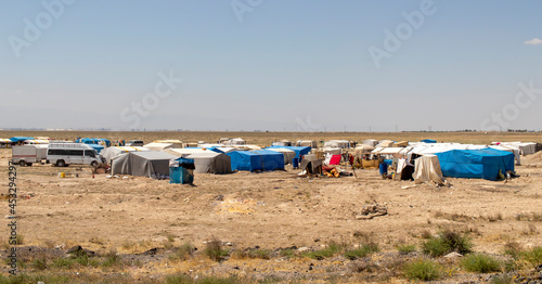 migrant tents, refugee camps. seasonal worker tents in an open area.