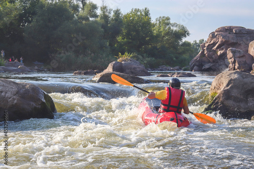 A man rowing inflatable packraft on whitewater of mountain river. Concept: summer extreme water sport,  active rest, extreme rafting. © Oleksandra
