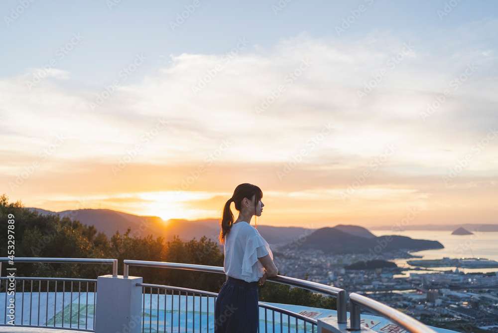 夕暮れの展望台にいる女性