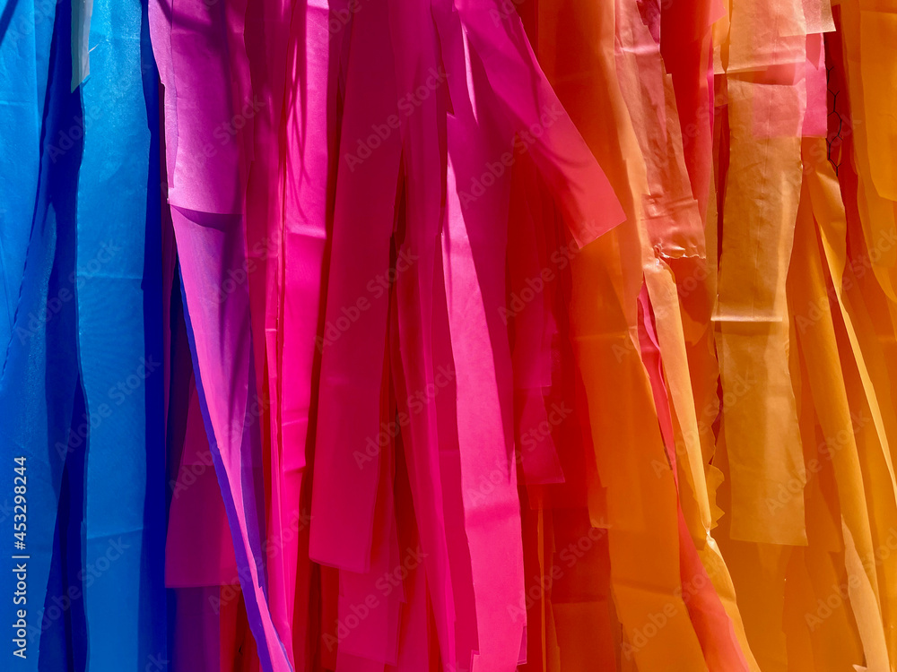 Colored silk ribbons hung in order to form a brightly colored gradient for use as a background decoration