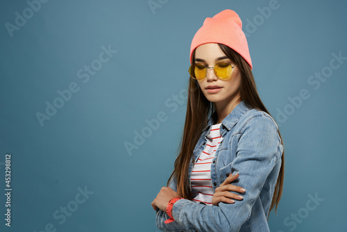 pretty woman wearing glasses modern clothing denim jacket blue background