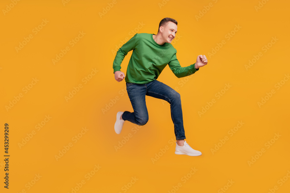Profile portrait of energetic athletic guy jump run rush shopping season on yellow background