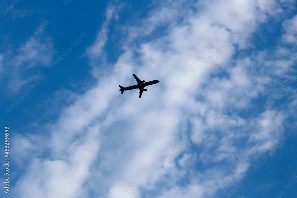 Silhouette of airplane flying in blue sky with white clouds in Vietnam Silhouette of airplane flying in blue sky with white clouds in Vietnam