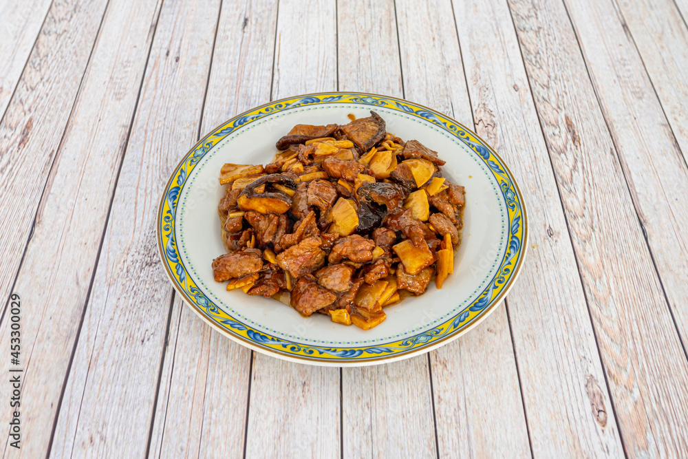 Chinese popular recipe of stewed beef with bamboo and Chinese mushrooms on white plate Chinese popular recipe of stewed beef with bamboo and Chinese mushrooms on white plate